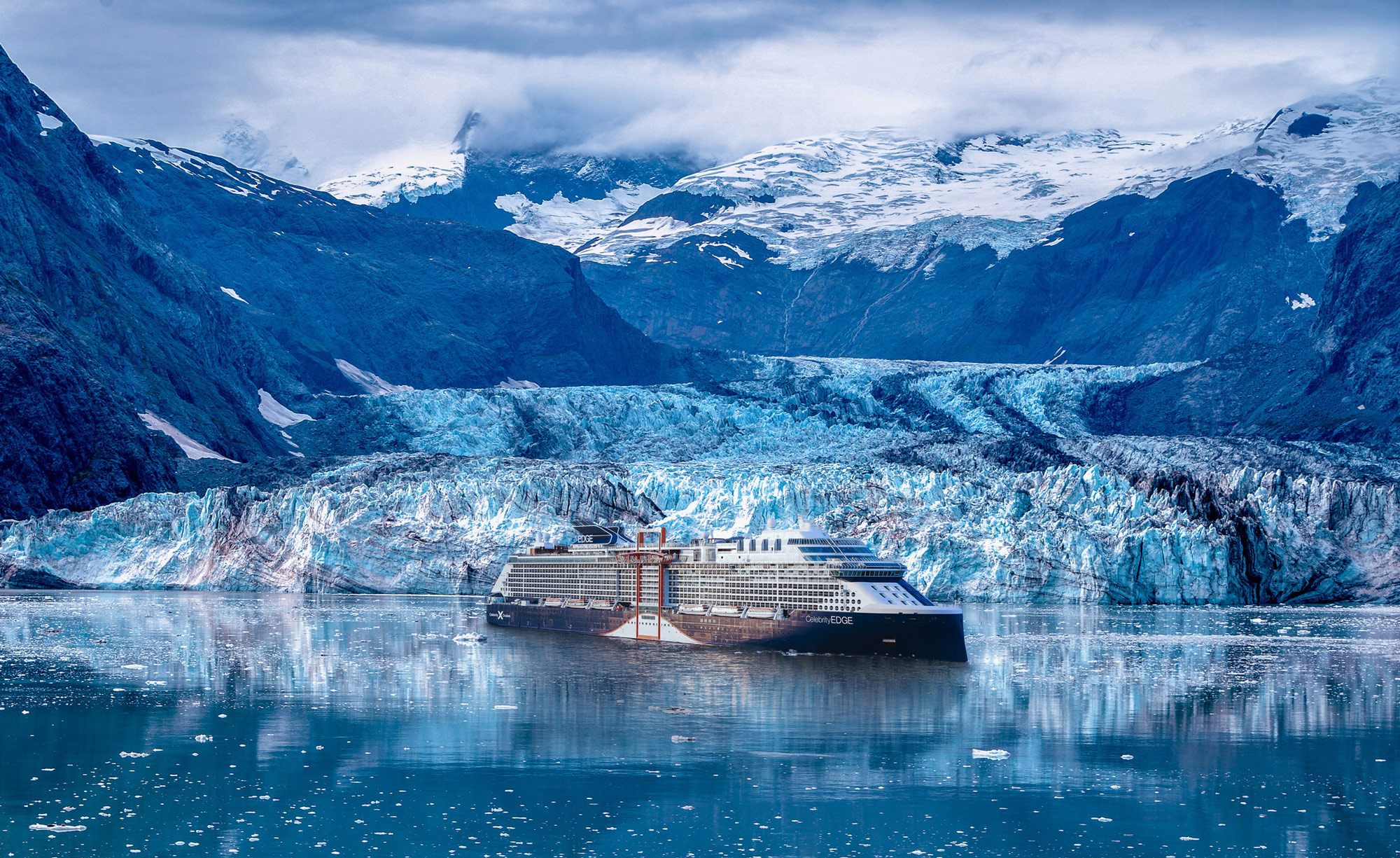 A vast landscape of pristine, rugged mountains and forests in Alaska.